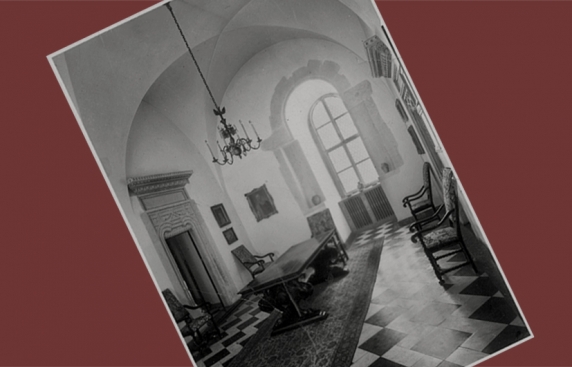 sala w zamku, wysokie okno zakończone łukowo, na ścianach obrazy, w sali ustawione zabytkowe meble - stół i krzesła