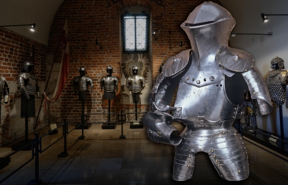 późnośredniowieczna zbroja turniejowa na tle ekspozycji zbroi w jednym z pomieszczeń Skarbca Koronnego i Zbrojowni Zamku Królewskiego na Wawelu