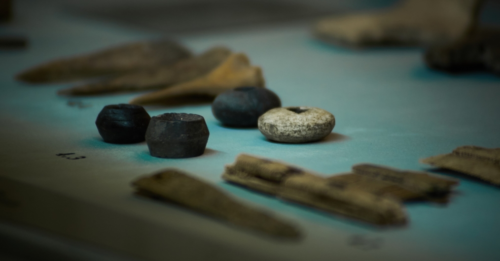 kilka przedmiotów z wykopalisk archeologicznych: koraliki narzędzia z kości