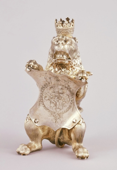 Srebrny lew z koroną, trzymający herb.
