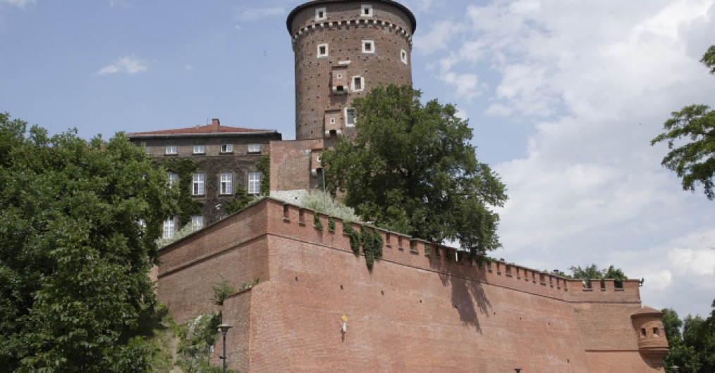 widok murów otaczających Wawel, ponad muram okrągła ceglana baszta, nakryta spadzistym dachem