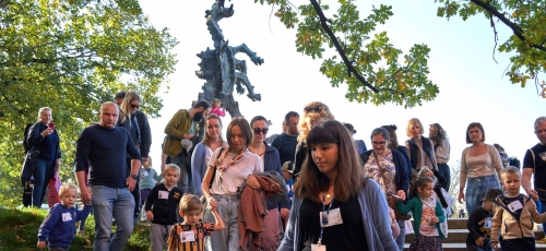 grupa dzieci z rodzicami, w tle rzeźba smoka wawelskiego