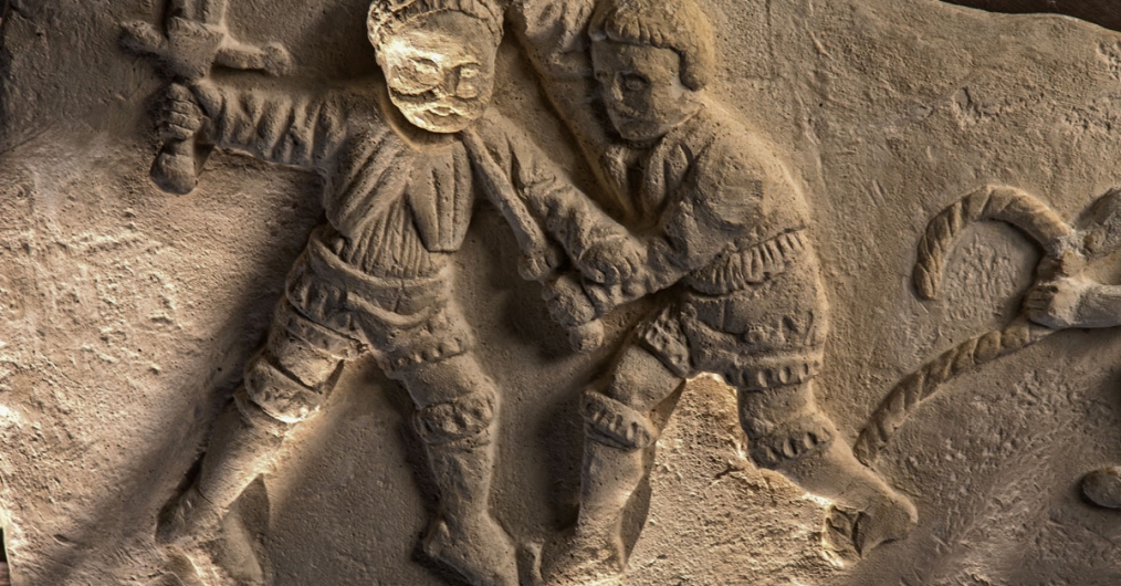 płaskorzeźba z przedstawieniem dwóch walczących postaci, jedna trzyma w uniesionej ręce miecz