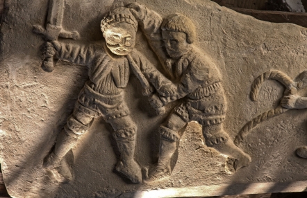 płaskorzeźba z przedstawieniem dwóch walczących postaci, jedna trzyma w uniesionej ręce miecz