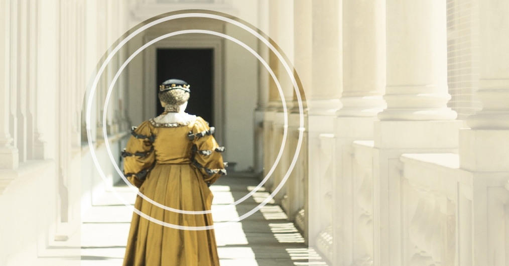 postać kobiety ubranej w złocistą suknię, idącej przez krużganki wawelskiego zamku