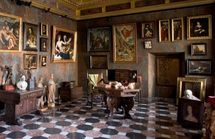 Zdjęcie przedstawia salę w Zamku, w wyposażeniu obrazy, rzeźby, meble, przedmioty codziennego użytku z różnych epok.