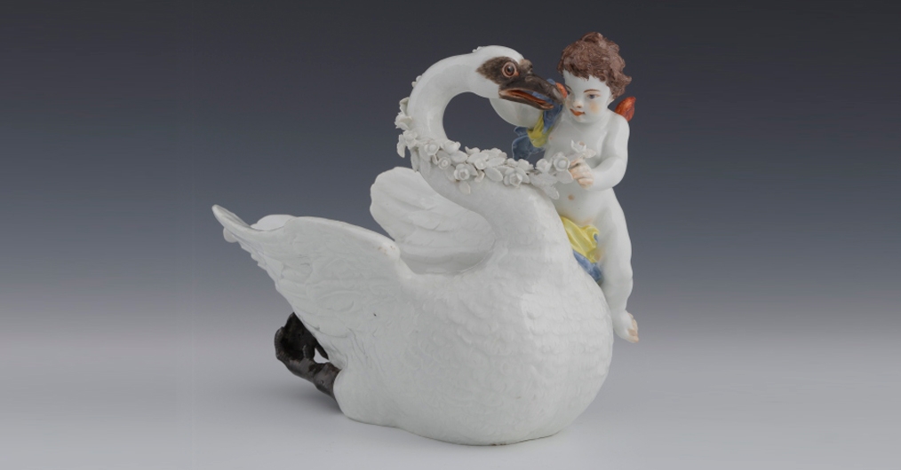 sosjerka - naczynie porcelanowe w kształcie łabędzia; na jego boku siedzi chłopiec