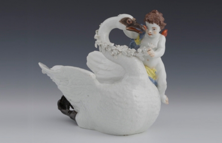 sosjerka - naczynie porcelanowe w kształcie łabędzia; na jego boku siedzi chłopiec