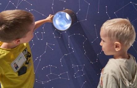 Dwójka chłopców patrząca na gwiazdozbiory na grantowym tle
