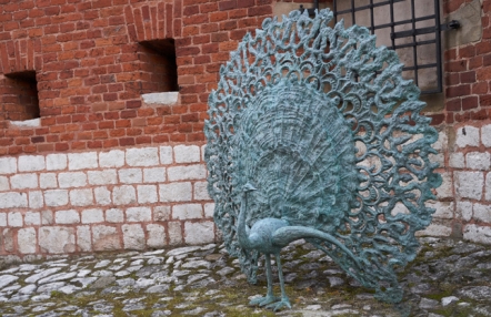 Rzeźba pawia na tle murów, przy wejściu do ogrodów królewskich