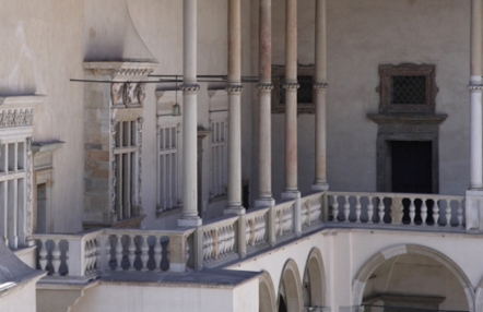 fragment krużganków wawelskich, z lewej strony zdobiony rzeźbami renesansowy portal okienny