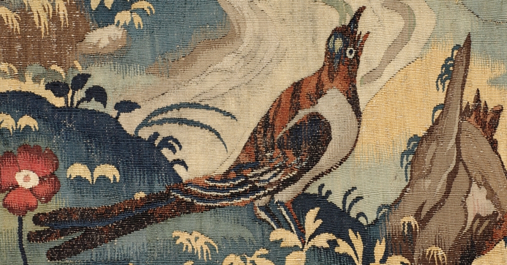 fragment arrasu, kolorowy ptak na tle kwiatów i trawy
