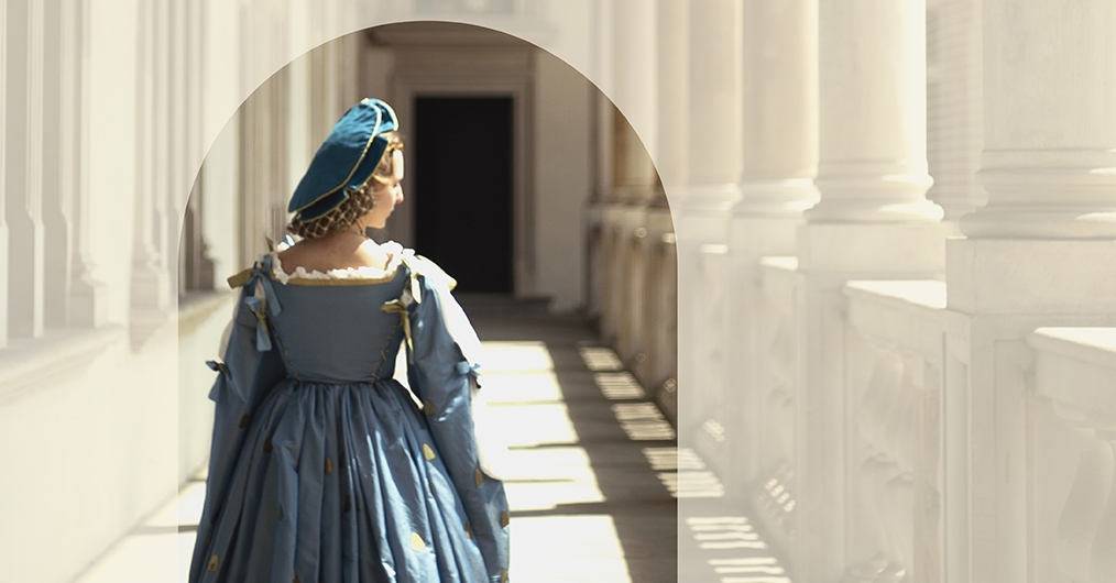 postać kobiety ubranej w niebieską suknię, idącej przez krużganki wawelskiego zamku