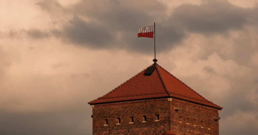 dach pokryty czeroną dachówką, na maszcie powiewa biało-czerwona flaga Polski