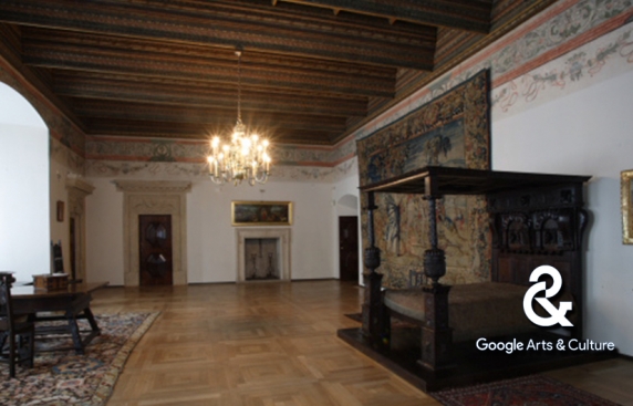 komnata w zamku, na ścianach obrazy, z prawej strony zabytkowe drewniane łoże z baldachimem