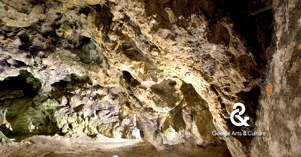 wnętrze jaskini, oświetlone lampami