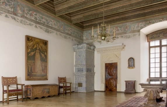 sala z eksponatami, obrazy, meble, kamienny portal, malowidła pod sufitem, drewniany strop, w narożniku piec kaflowy