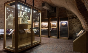 sala wystawy Wawel Odzyskany, sala w piwnicy, na ścianach i w gablotach obiekty zabytkowe