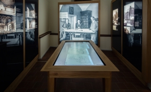 Wystawa Wawel Odzyskany, korytarz ze zdjęciami na ścianach i stołem multimedialnym