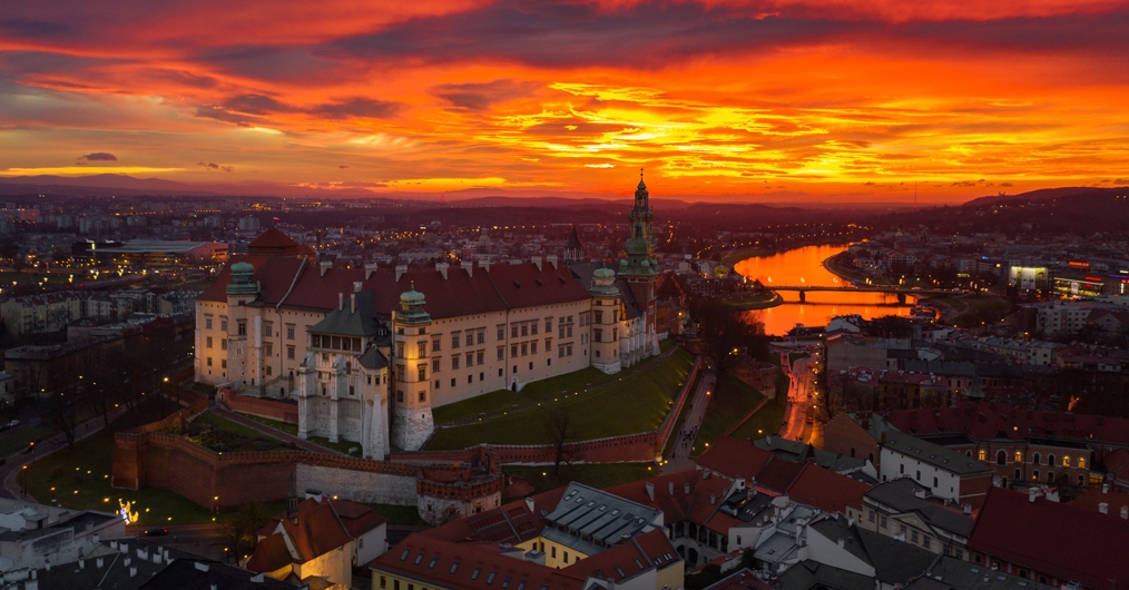 widok z lotu ptaka na Kraków i wzgórze wawelskie, oświetlone nastrojowym światłem zachodzącego słońca