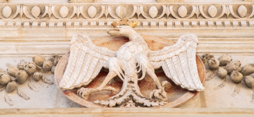 fragment portalu renesansowego, bogato zdobionego rzeźbiarsko, na pierwszym planie orzeł z rozłożonymi skrzydłami, w złotej koroni