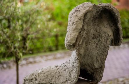 fragment rzeźby przedstawiającej siedzącą postać