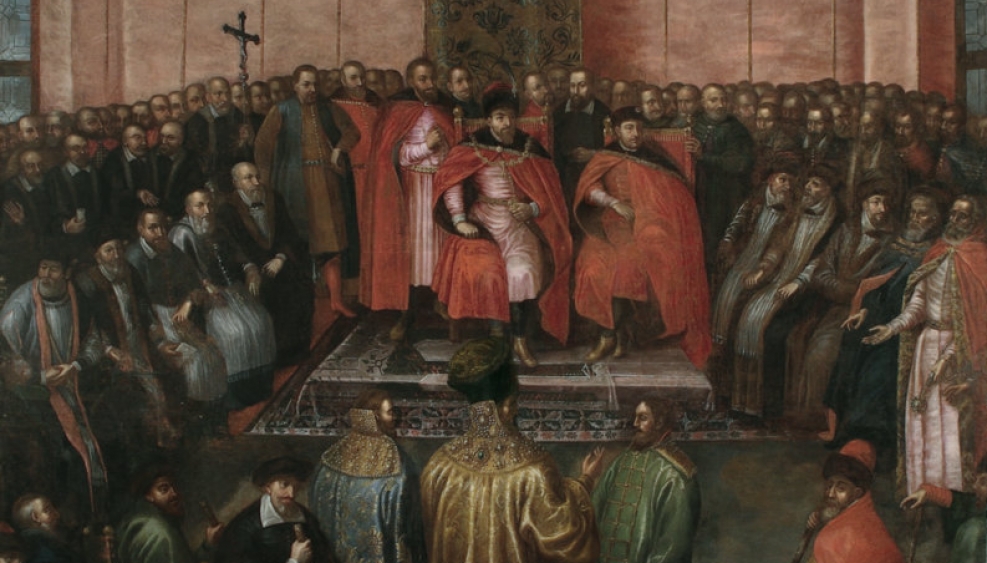 grupa ludzi w średniowiecznych szatach, możnowładcy stoją przed królem
