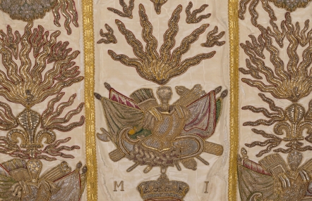 fragment ornatu, haftowane złoto-srebrne emblematy kościelne, na jasnej jedwabnej tkanienie