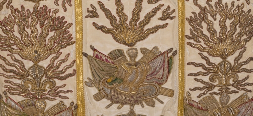 fragment ornatu, haftowane złoto-srebrne emblematy kościelne, na jasnej jedwabnej tkanienie