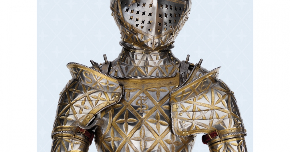 Metalowa zbroja wraz z hełmem ze złotymi ornamentami, ukazana od piersi w górę.