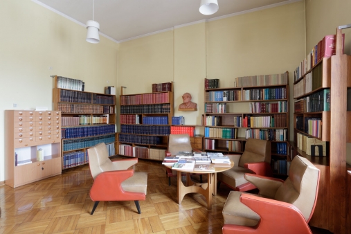 Współczesne wnętrze biblioteki - narożnik z małym, okrągłym stolikiem i czterema fotelami zaprojektowanymi przez Mariana Sigmunda.