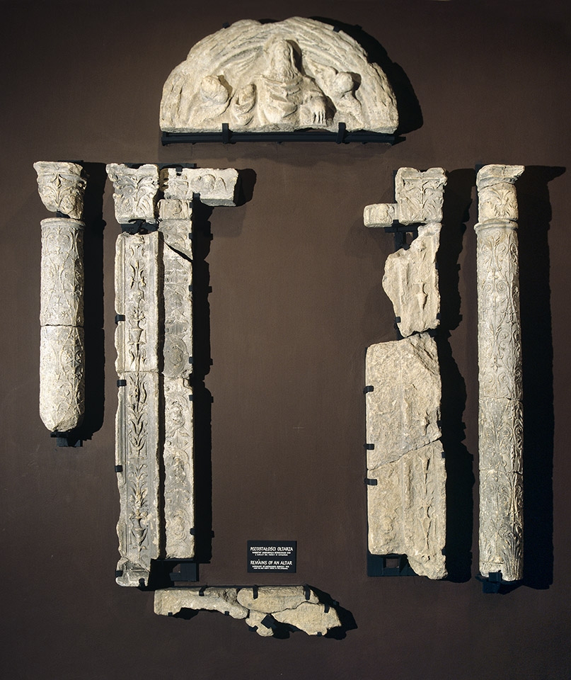 Fragmenty kamiennego ołtarza zwanego zatorskim, składającego się z tympanonu z przedstawieniem Boga Ojca, pary kolumn i pilastrów, ramy zdobionej ornamentem kandelabrowym oraz tablicy fundacyjnej.