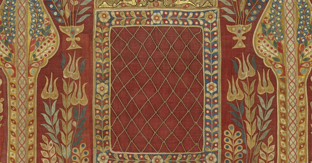 fragment namiotu tureckiego, zdobiony ornamentami geometrycznymi i roślinnymi; dominuje kolor czerwony i złoty