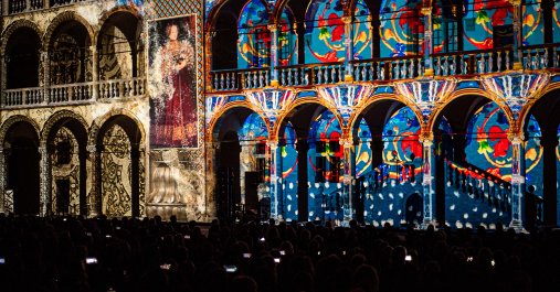 Pokaz świetlny wyświetlany na ścianach budynku, tworzący kolorowe wzory i efekty wizualne.