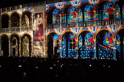 Pokaz świetlny wyświetlany na ścianach budynku, tworzący kolorowe wzory i efekty wizualne.