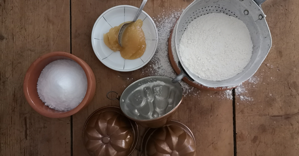naczynia kuchenne: miseczka z msem jabłkowym, miseczka z solą, sitko z mąką, foremki do pieczenia