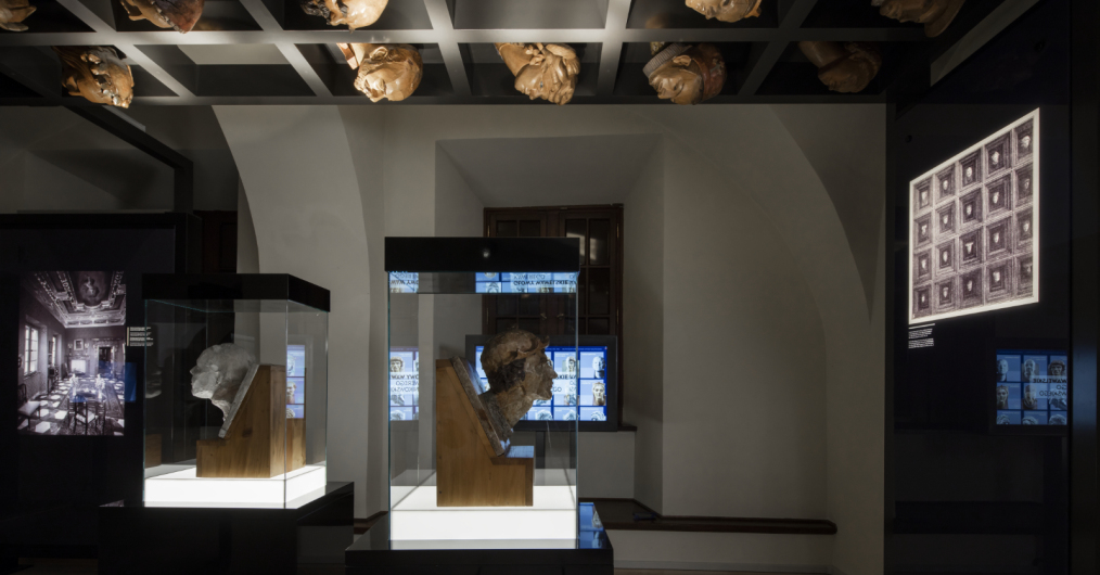 zaciemniona sala muzealna z zabytkami w gablotach