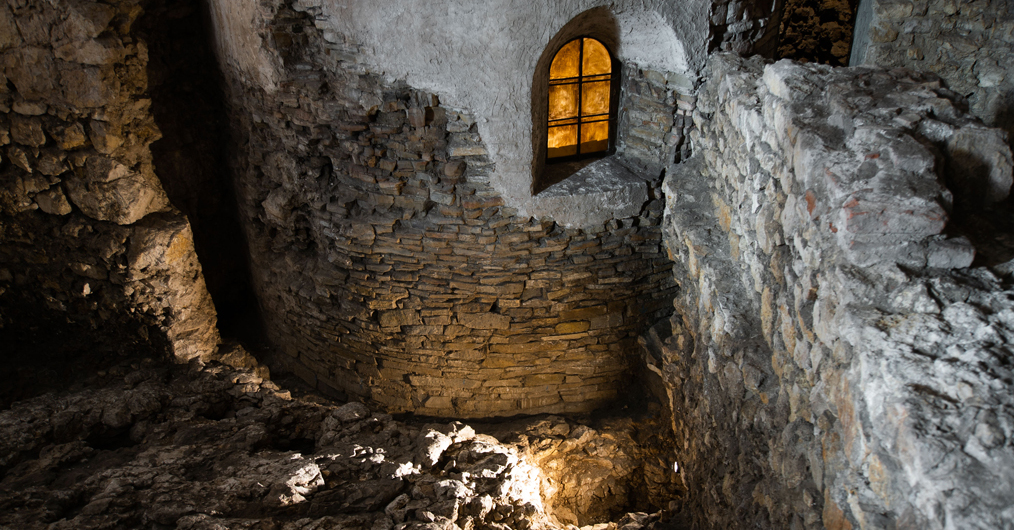 zaciemniona sala muzealna z zabytkami w gablotach