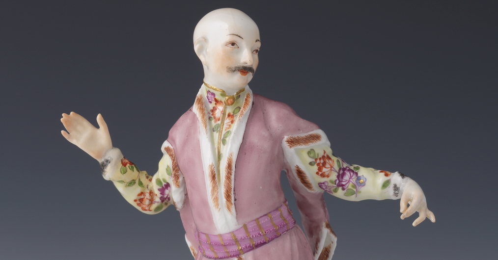 figurka porcelanowa, postać mężczyzny w szlacheckim ubraniu, ramiona rozłożone w tanecznym geście