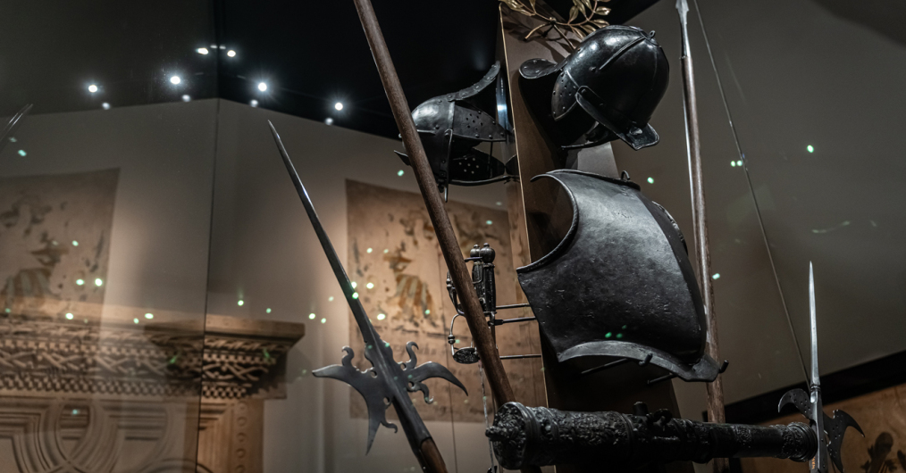 zaciemniona sala muzealna z zabytkowymi zbrojami