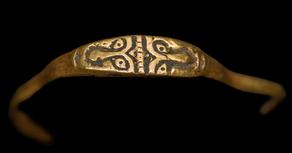 złoty pierścień zdobiony rytymi dwoma twarzami antycznego bóstwa