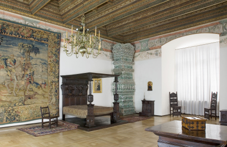 sala muzealna w zamku, na ścianie arras, w rogu łóże z baldachimem