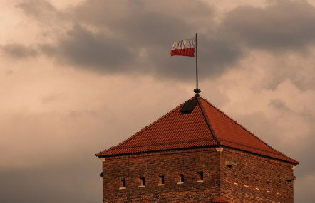 dach pokryty czeroną dachówką, na maszcie powiewa biało-czerwona flaga Polski