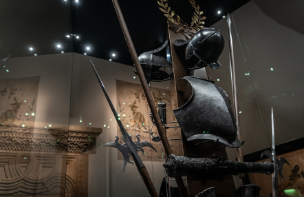 zaciemniona sala muzealna z zabytkowymi zbrojami