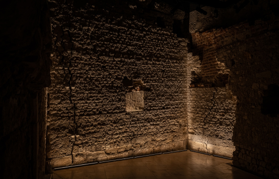 Wnętrze starego kamienno-ceglanego budynku z kamienną podłogą, ukazujące surowy urok architektury.