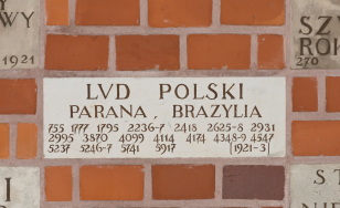 fragment ceglanego muru z wbudowanym do niego kawałkiem kamienia, na kamieniu napis z zanwiskiem fundatora