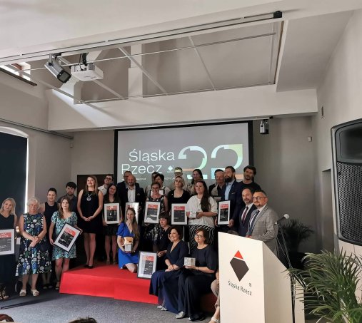 grupa ludzi pozuje do zdjęcia w jasnym, nowoczesnym wnętrzu