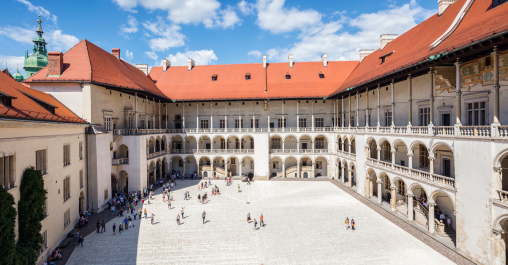 Wielki dziedziniec zamkowy, pokryty kamienną kostką, otoczony z trzech stron budynkami, każde piętro posiada bogato zdobione krużganki, czyli rodzaj balkonu, na budynku z lewej strony winorośl