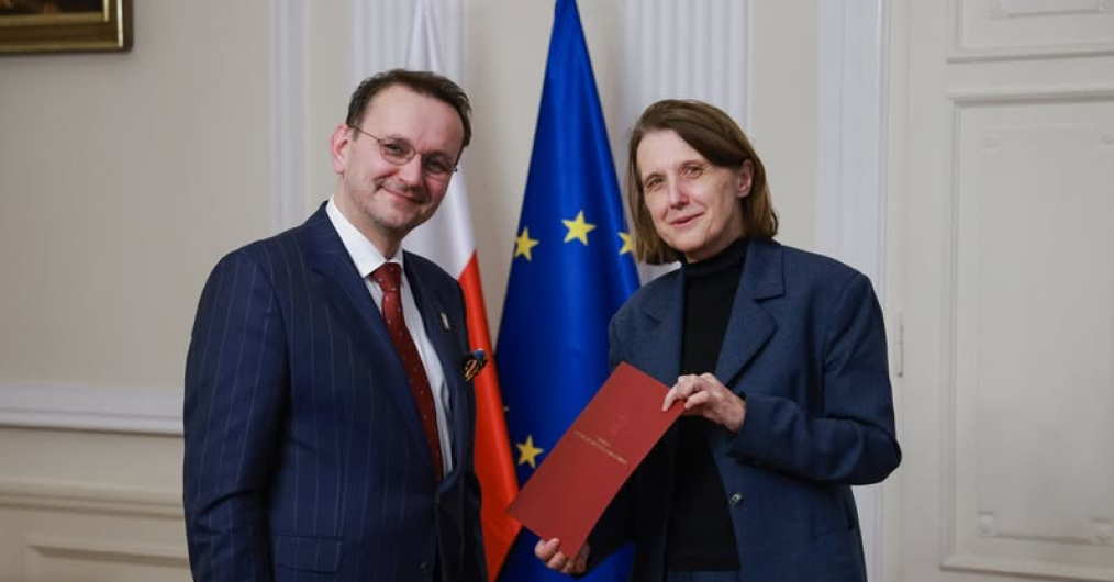 uśmiechnięty mężczyzna i kobieta na na tle ściany i flagi unijnej