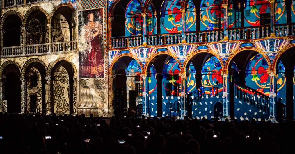 Pokaz świetlny wyświetlany na ścianach budynku, tworzący kolorowe wzory i efekty wizualne.